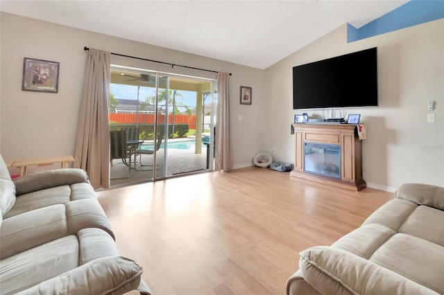 1216 Cheshire St, Groveland, FL 34736 - living room with lofted ceiling, a glass covered fireplace, and wood finished floors