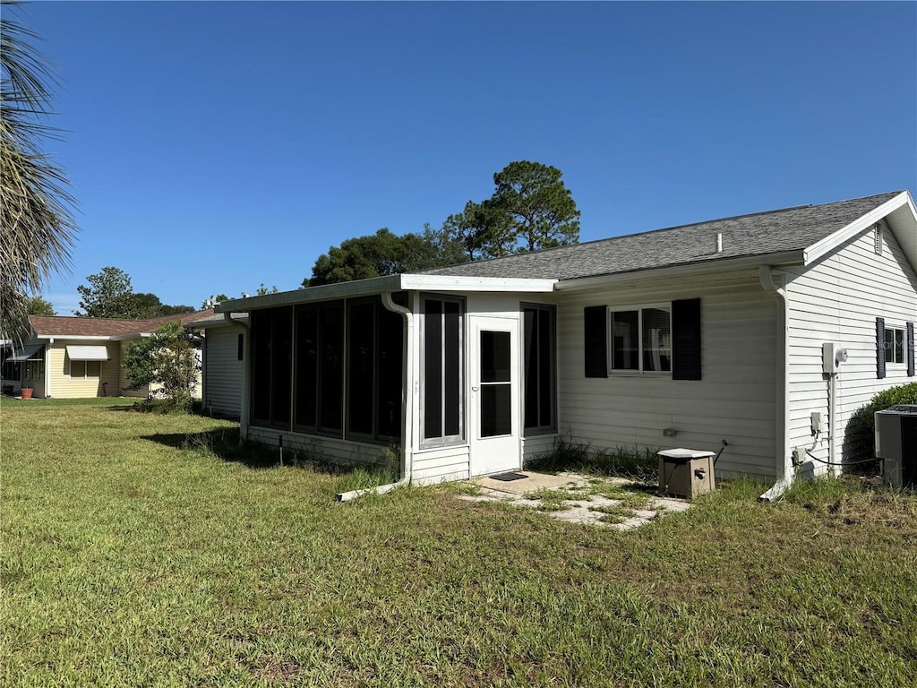 8344 SW 107th Pl, Ocala, FL 34481 - back of property with a sunroom, a yard, and roof with shingles