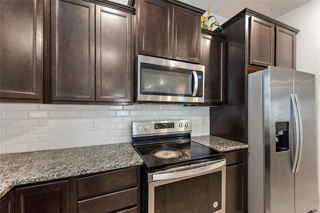 120 Citrus Isle St, Davenport, FL 33837 - kitchen with stainless steel appliances, tasteful backsplash, dark brown cabinetry, and dark stone countertops