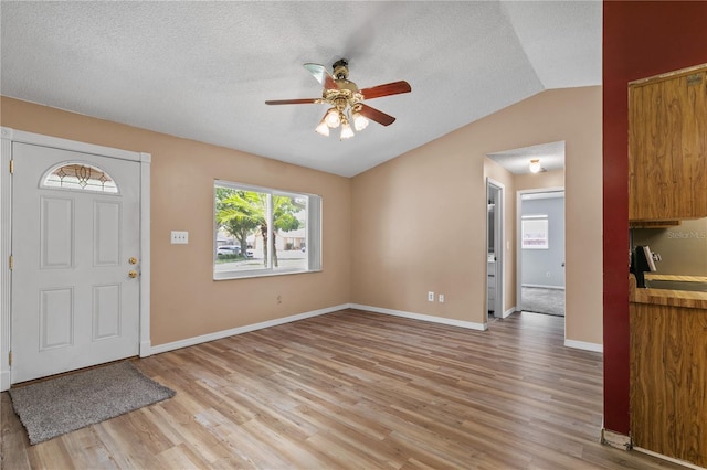 461 Kee St, Apopka, FL 32712 - foyer entrance with a ceiling fan, lofted ceiling, light wood-type flooring, and a textured ceiling