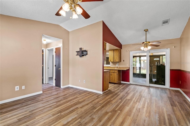 461 Kee St, Apopka, FL 32712 - unfurnished living room featuring a ceiling fan, vaulted ceiling, light wood finished floors, and a textured ceiling
