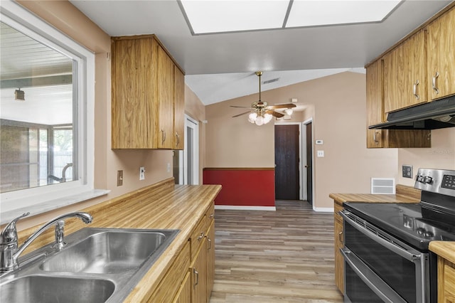 461 Kee St, Apopka, FL 32712 - kitchen with double oven range, under cabinet range hood, vaulted ceiling, butcher block counters, and light wood finished floors