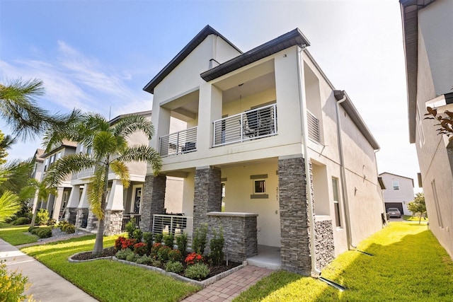 2163 White Feather Loop, Oakland, FL 34787 - contemporary home with stone siding, stucco siding, a balcony, and a front lawn