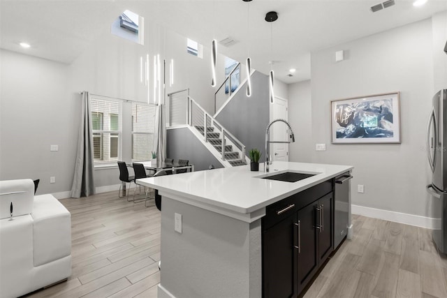 2163 White Feather Loop, Oakland, FL 34787 - kitchen with stainless steel appliances, light wood-style floors, light countertops, dark cabinetry, and recessed lighting