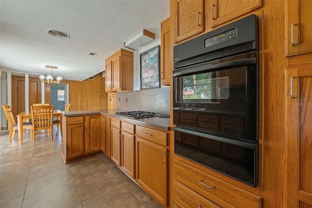 138 W 52nd St, Hialeah, FL 33012 - kitchen with a peninsula, a warming drawer, a chandelier, stainless steel gas cooktop, and brown cabinets