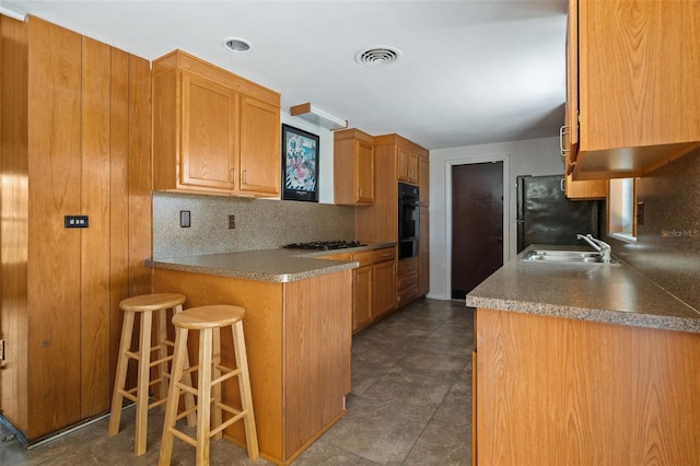 138 W 52nd St, Hialeah, FL 33012 - kitchen featuring black appliances, a kitchen bar, a peninsula, decorative backsplash, and a warming drawer