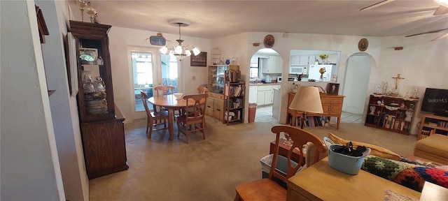 13420 Debbie Ln, Clermont, FL 34715 - dining area featuring a ceiling fan, arched walkways, a chandelier, light colored carpet, and light tile patterned floors