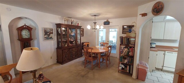 13420 Debbie Ln, Clermont, FL 34715 - dining area with arched walkways, a chandelier, and light colored carpet