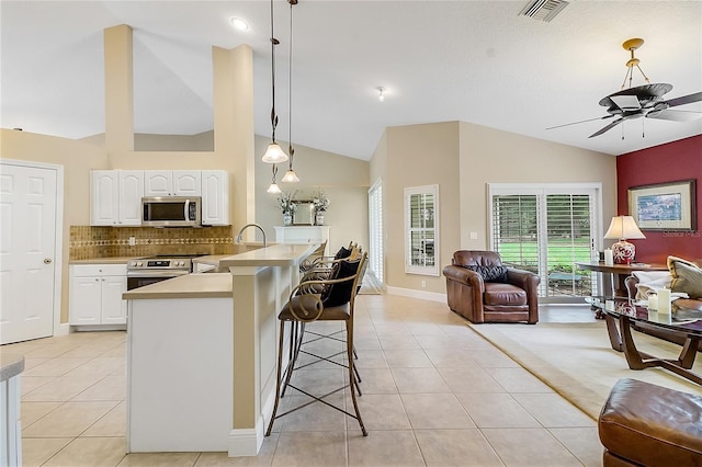5349 Grove Mnr, Lady Lake, FL 32159 - kitchen featuring appliances with stainless steel finishes, open floor plan, a ceiling fan, a breakfast bar area, and light tile patterned flooring
