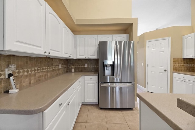 5349 Grove Mnr, Lady Lake, FL 32159 - kitchen with stainless steel fridge with ice dispenser, light tile patterned flooring, white cabinets, backsplash, and light countertops