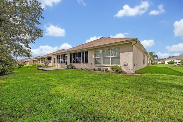 11816 SE 91st Cir, Summerfield, FL 34491 - rear view of property with a lawn, stucco siding, and a patio area