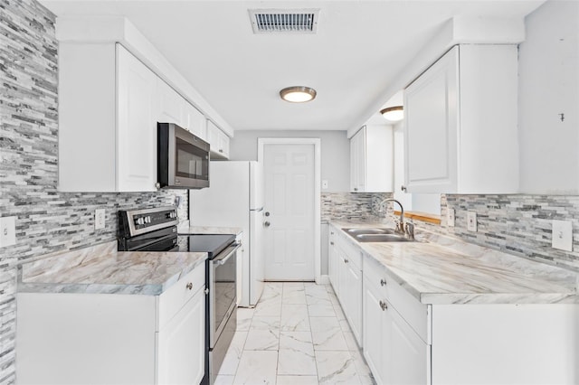 11326 Yellowwood Ln, Port Richey, FL 34668 - kitchen featuring appliances with stainless steel finishes, light marble finish floors, light countertops, and tasteful backsplash