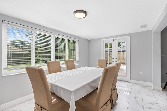 11326 Yellowwood Ln, Port Richey, FL 34668 - dining space featuring healthy amount of natural light, light marble finish flooring, and french doors