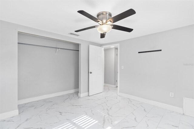 11326 Yellowwood Ln, Port Richey, FL 34668 - unfurnished bedroom with light marble finish flooring, a closet, and a ceiling fan