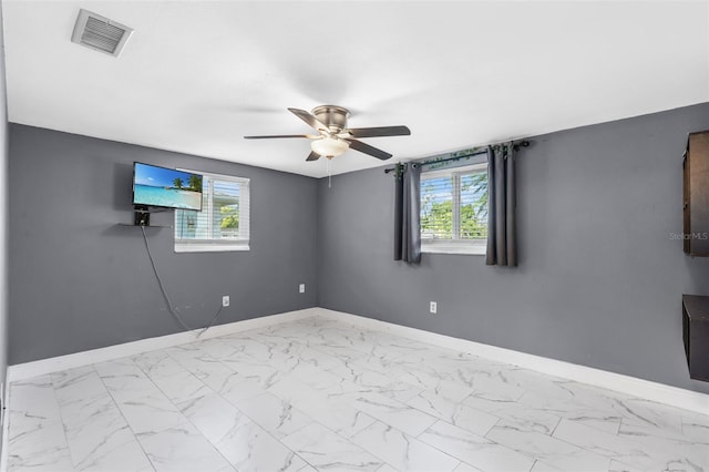 11326 Yellowwood Ln, Port Richey, FL 34668 - spare room featuring a ceiling fan, plenty of natural light, and marble finish flooring