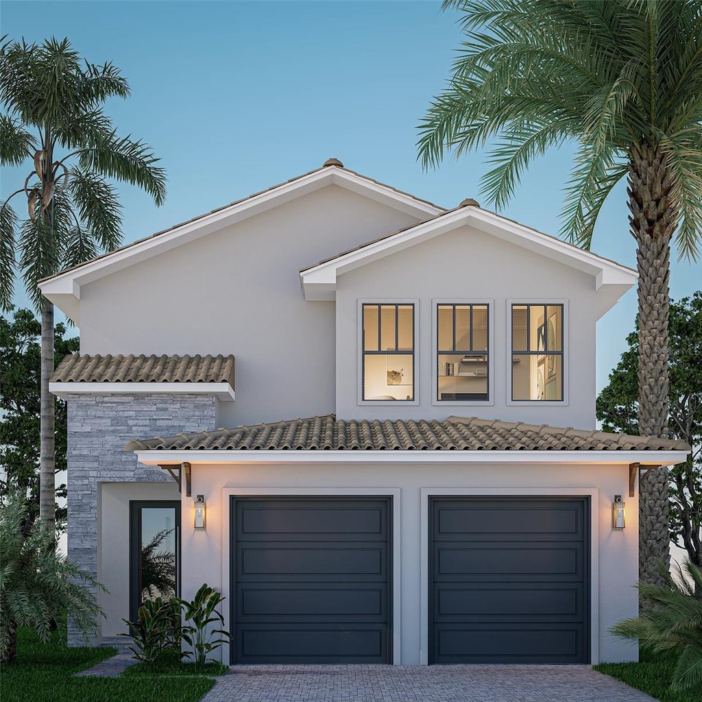 view of front of property featuring decorative driveway, an attached garage, stucco siding, and stone siding
