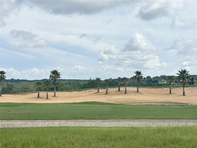 view of community featuring view of golf course and a lawn