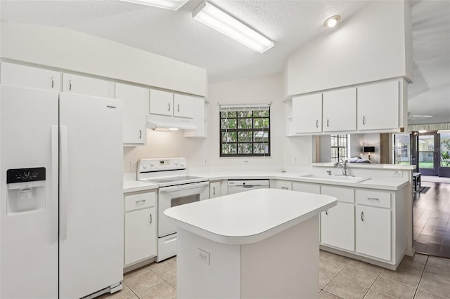 324 Juniper Way, Tavares, FL 32778 - kitchen with white appliances, under cabinet range hood, light countertops, a peninsula, and a textured ceiling