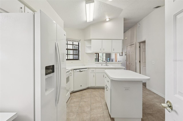 324 Juniper Way, Tavares, FL 32778 - kitchen featuring white appliances, a textured ceiling, light countertops, a center island, and light tile patterned floors