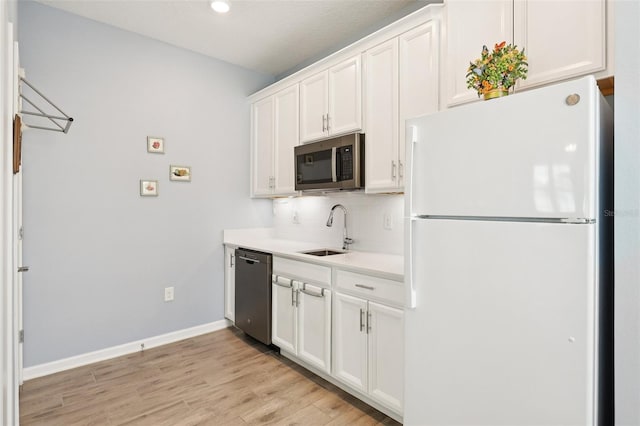 49 White Horse Way, Groveland, FL 34736 - kitchen with appliances with stainless steel finishes, backsplash, white cabinetry, light countertops, and light wood-style floors