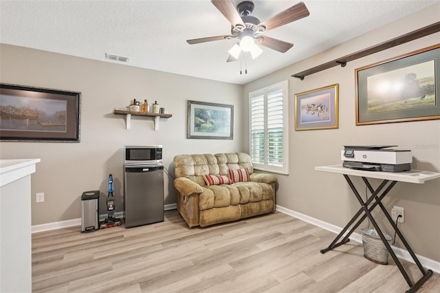 49 White Horse Way, Groveland, FL 34736 - living room featuring light wood finished floors, ceiling fan, and a textured ceiling
