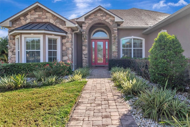 18139 Great Blue Heron Dr, Groveland, FL 34736 - doorway to property with stone siding, a shingled roof, and stucco siding