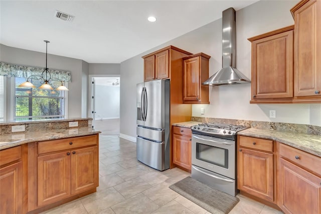 18139 Great Blue Heron Dr, Groveland, FL 34736 - kitchen featuring stainless steel appliances, wall chimney exhaust hood, light stone countertops, brown cabinetry, and hanging light fixtures