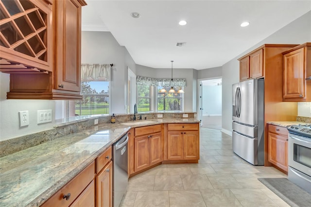 18139 Great Blue Heron Dr, Groveland, FL 34736 - kitchen with appliances with stainless steel finishes, light stone countertops, a peninsula, brown cabinets, and recessed lighting