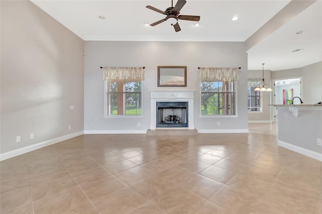 18139 Great Blue Heron Dr, Groveland, FL 34736 - unfurnished living room featuring light tile patterned floors, a ceiling fan, a fireplace, ornamental molding, and a chandelier