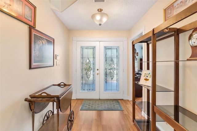 1412 Cove Pl, Tavares, FL 32778 - entrance foyer with french doors, light wood-type flooring, and a textured ceiling