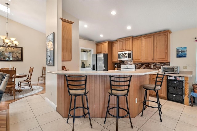 1412 Cove Pl, Tavares, FL 32778 - kitchen with appliances with stainless steel finishes, vaulted ceiling, light countertops, a breakfast bar, and backsplash
