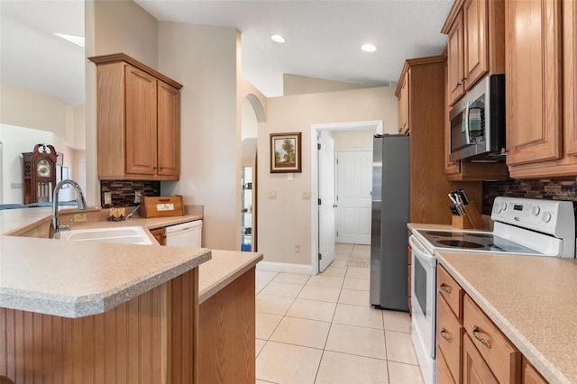 1412 Cove Pl, Tavares, FL 32778 - kitchen featuring stainless steel appliances, backsplash, vaulted ceiling, arched walkways, and light tile patterned flooring
