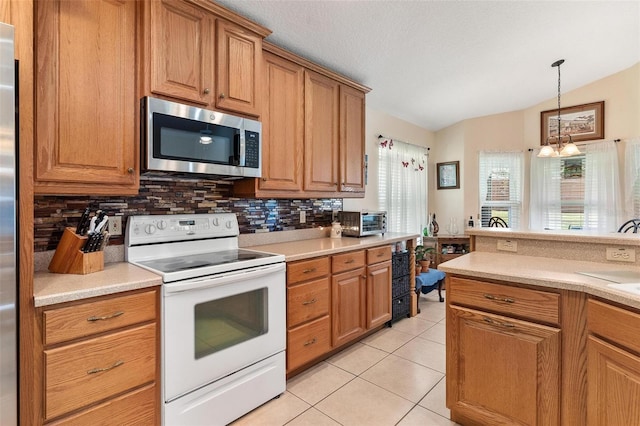 1412 Cove Pl, Tavares, FL 32778 - kitchen featuring appliances with stainless steel finishes, tasteful backsplash, light countertops, brown cabinets, and lofted ceiling