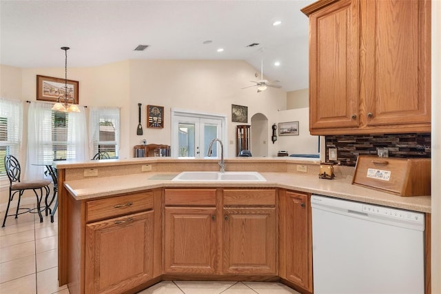 1412 Cove Pl, Tavares, FL 32778 - kitchen featuring white dishwasher, plenty of natural light, arched walkways, light tile patterned floors, and vaulted ceiling
