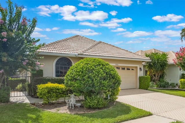 9015 Saint Andrews Way, Mount Dora, FL 32757 - view of front of house with stucco siding, an attached garage, driveway, and a tile roof