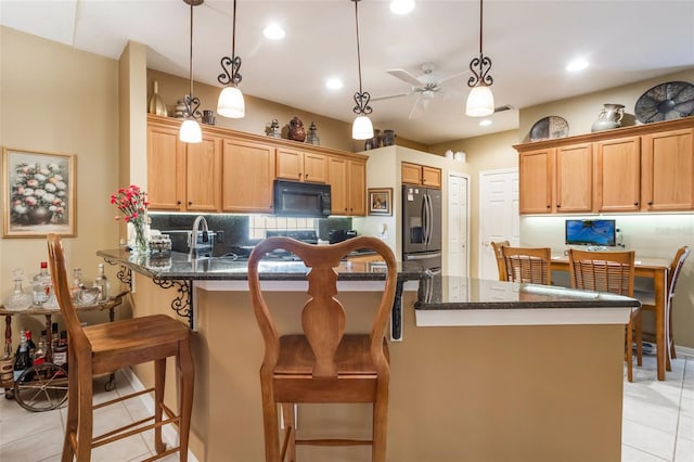 9015 Saint Andrews Way, Mount Dora, FL 32757 - kitchen with black microwave, stainless steel refrigerator with ice dispenser, a peninsula, light tile patterned floors, and hanging light fixtures