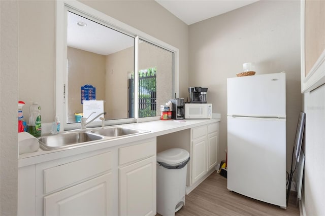 9015 Saint Andrews Way, Mount Dora, FL 32757 - kitchen featuring white appliances, light wood finished floors, white cabinets, and light countertops