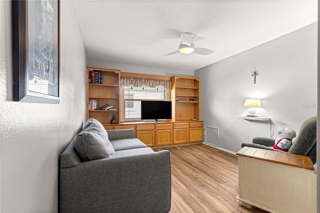 89 Palermo Pl, The Villages, FL 32159 - living room featuring ceiling fan, light wood-style floors, and a textured ceiling