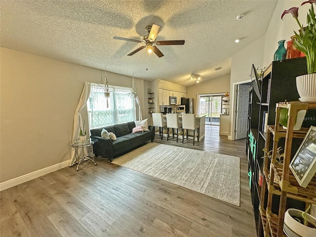 7047 Hickory Branch Cir, Orlando, FL 32818 - living area featuring a textured ceiling, a ceiling fan, wood finished floors, and lofted ceiling