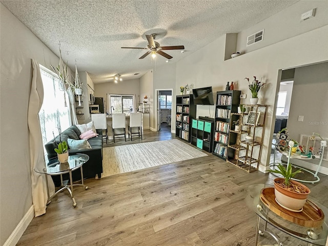 7047 Hickory Branch Cir, Orlando, FL 32818 - sitting room featuring a textured ceiling, ceiling fan, wood finished floors, and vaulted ceiling