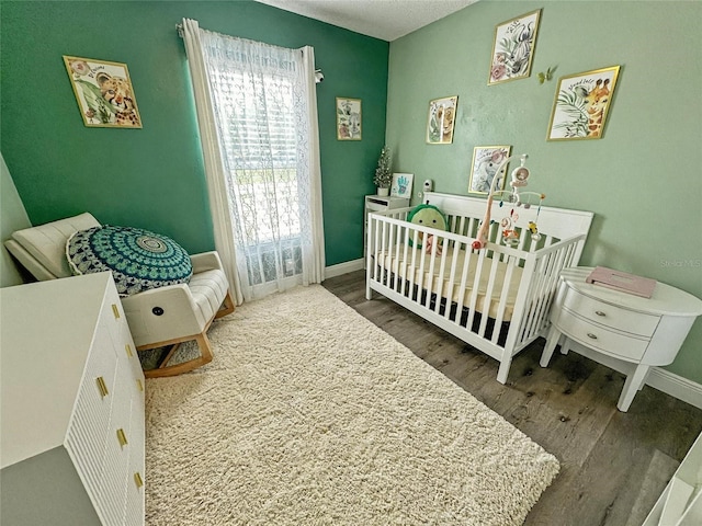 7047 Hickory Branch Cir, Orlando, FL 32818 - bedroom featuring wood finished floors and a crib