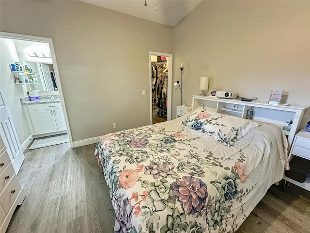 7047 Hickory Branch Cir, Orlando, FL 32818 - bedroom featuring wood finished floors, a spacious closet, a closet, lofted ceiling, and ensuite bath