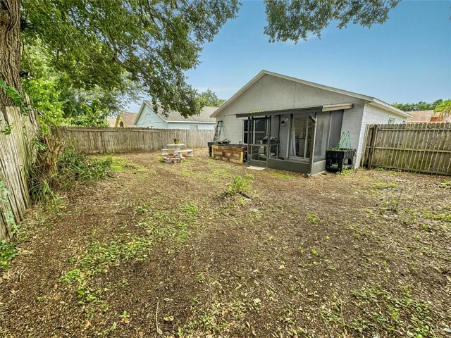 7047 Hickory Branch Cir, Orlando, FL 32818 - back of property featuring concrete block siding, a sunroom, and a fenced backyard