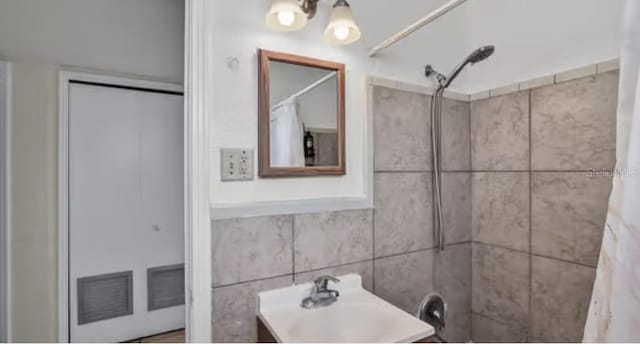 5912 Navajo Way, Orlando, FL 32807 - bathroom with tile walls, a tile shower, and vanity