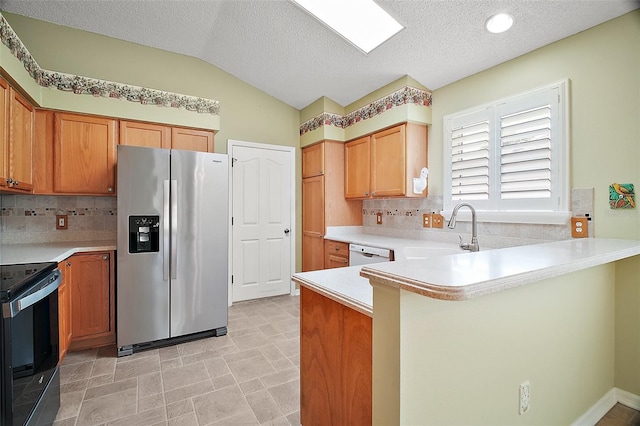 182 Palermo Pl, Lady Lake, FL 32159 - kitchen with stainless steel refrigerator with ice dispenser, electric range oven, a peninsula, backsplash, and a textured ceiling