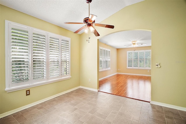 182 Palermo Pl, Lady Lake, FL 32159 - empty room with a ceiling fan, a textured ceiling, arched walkways, and vaulted ceiling