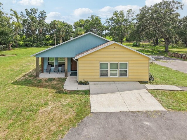 40535 Louise Rd, Umatilla, FL 32784 - bungalow-style home with a front yard, covered porch, driveway, and view of wooded area