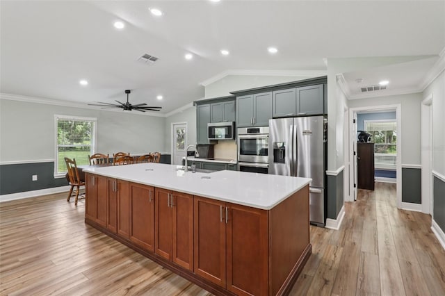 40535 Louise Rd, Umatilla, FL 32784 - kitchen with appliances with stainless steel finishes, ornamental molding, light countertops, lofted ceiling, and light wood-type flooring