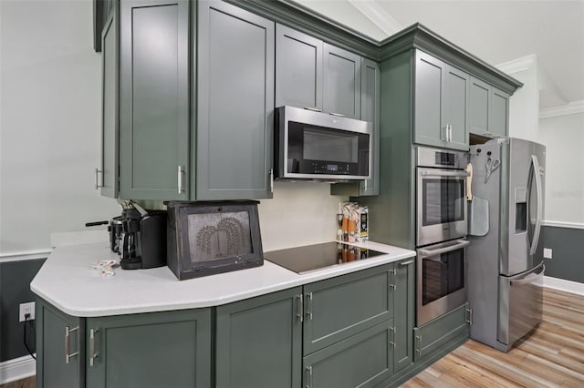 40535 Louise Rd, Umatilla, FL 32784 - kitchen with stainless steel appliances, green cabinetry, crown molding, light wood-style flooring, and light countertops