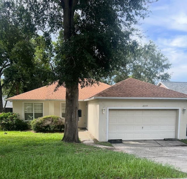 ranch-style house featuring an attached garage, stucco siding, concrete driveway, a front yard, and roof with shingles